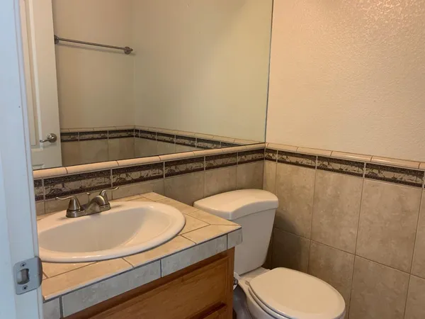 a bathroom with a sink a toilet and a mirror