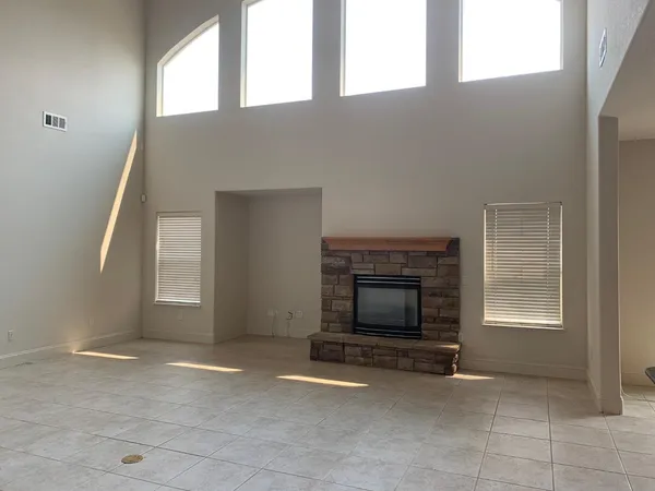an empty room with windows and fireplace