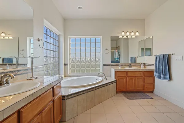 a bathroom with a tub sink and mirror