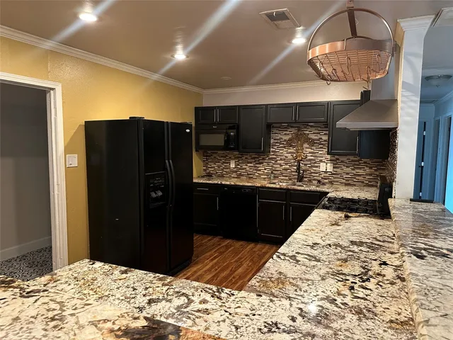 a kitchen with stainless steel appliances granite countertop a stove a sink and a refrigerator