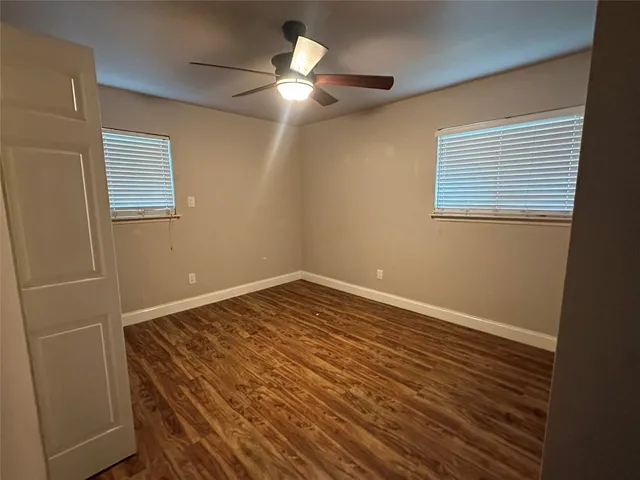 an empty room with wooden floor and entrance