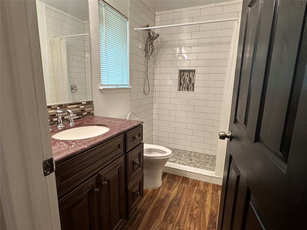 6004 Palm Circle Austin, TX 78741 - Photo 14 of 27 a bathroom with a granite countertop sink toilet and shower