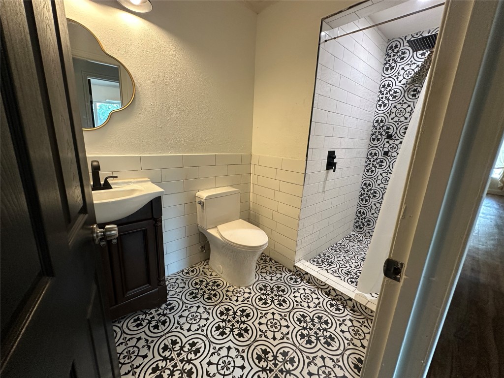 6004 Palm Circle Austin, TX 78741 - Photo 18 of 27 a bathroom with a sink a toilet a mirror and shower