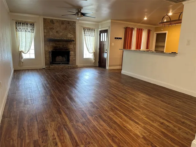 an empty room with wooden floor and a fireplace