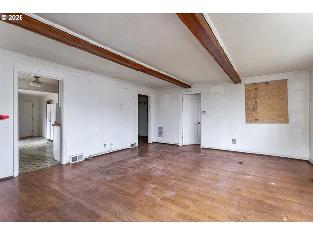 a view of an empty room with wooden floor