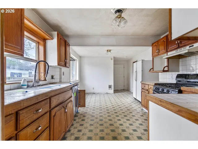 a kitchen with stainless steel appliances granite countertop a sink stove and cabinets