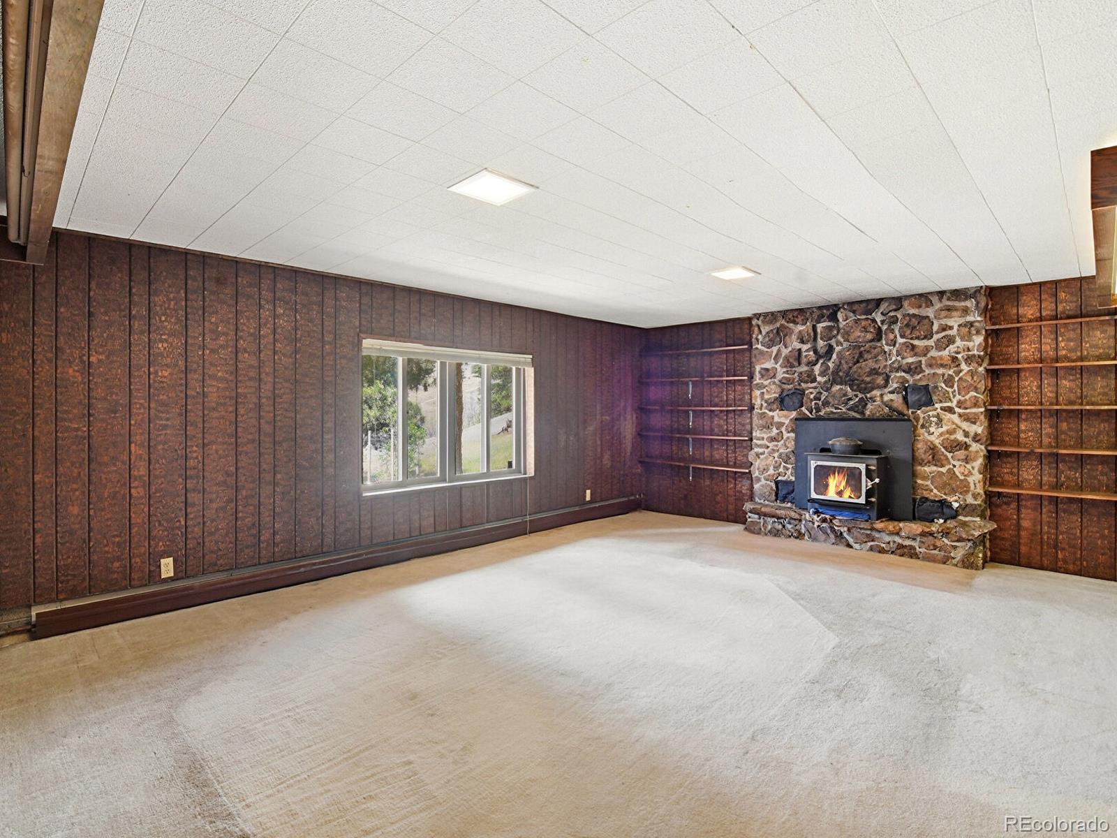 2830 Kerr Gulch Road Evergreen, CO 80439 - Photo 30 of 48 an empty room with windows and fireplace