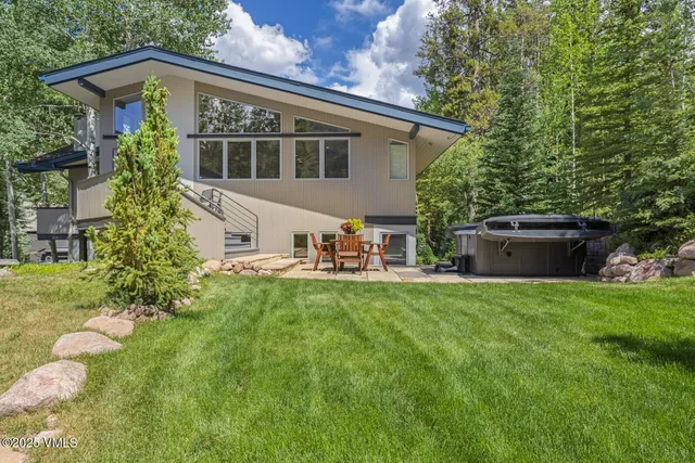 a view of a house with backyard sitting area and garden