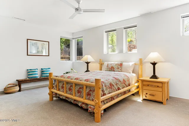 a spacious bedroom with a bed and a lamp