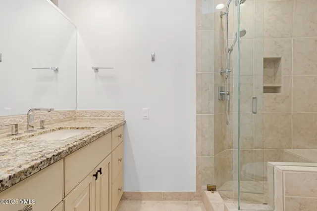 a bathroom with a granite countertop sink and a mirror