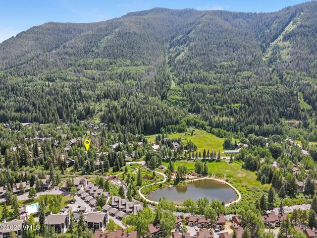 an aerial view of residential house with outdoor space and trees all around