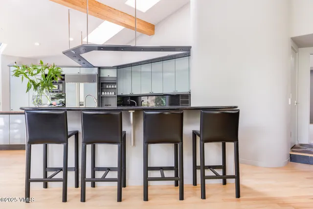 a kitchen with stainless steel appliances kitchen island granite countertop a table chairs and a refrigerator