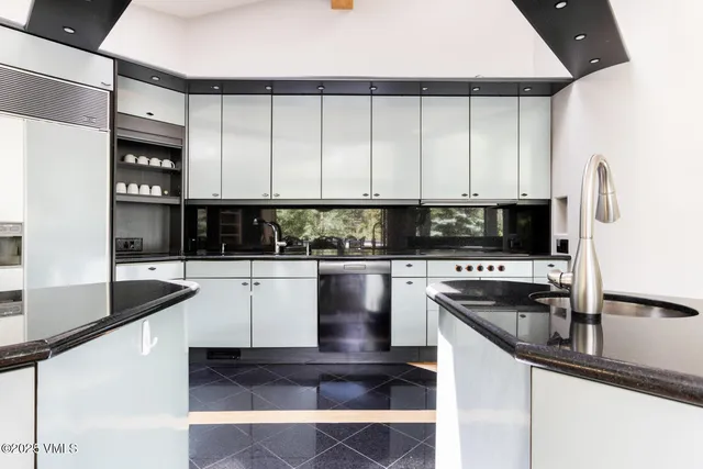 a kitchen with stainless steel appliances granite countertop a sink a stove and a refrigerator