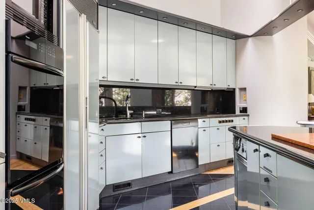 a kitchen with stainless steel appliances white cabinets and a refrigerator