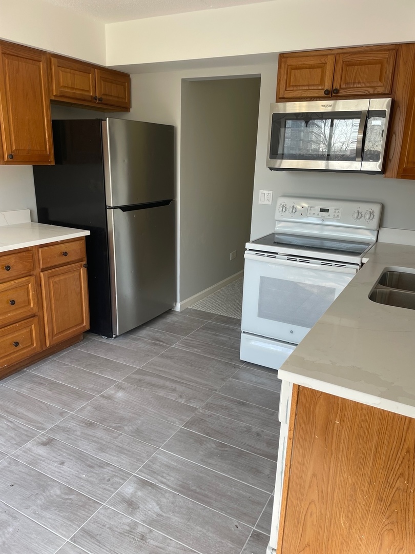 5500 Tinder, Unit 2 Rolling Meadows, IL 60008 - Photo 3 of 14 a kitchen with a refrigerator and a stove