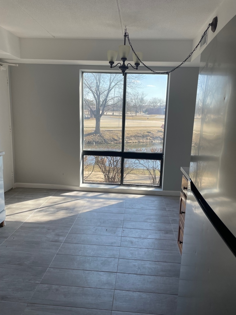 5500 Tinder, Unit 2 Rolling Meadows, IL 60008 - Photo 6 of 14 a view of an empty room with wooden floor and a window