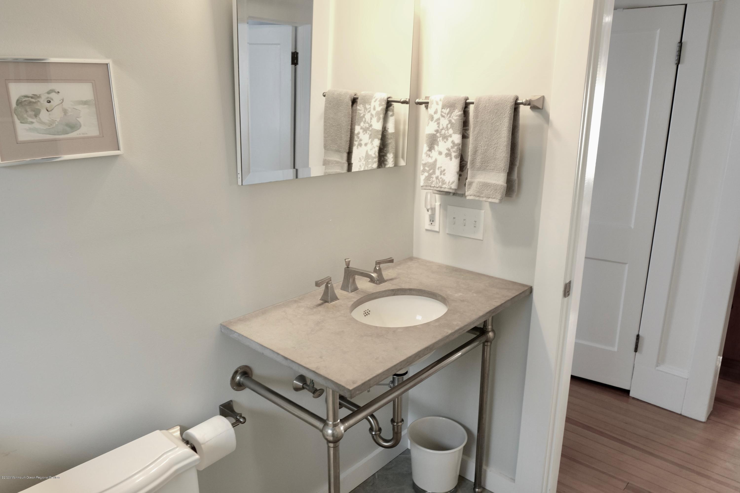 220 Lincoln Avenue, Unit 1 Avon-by-the-Sea, NJ 07717 - Photo 19 of 26 a bathroom with a sink and mirror with toilet
