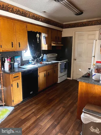 a kitchen with stainless steel appliances granite countertop a stove a sink dishwasher and cabinets with wooden floor