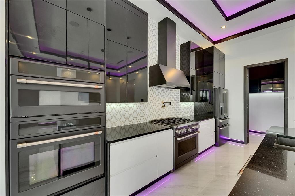 6532 Simone Shores Circle Apollo Beach, FL 33572 - Photo 34 of 86 a kitchen with stainless steel appliances kitchen island granite countertop a stove and a microwave