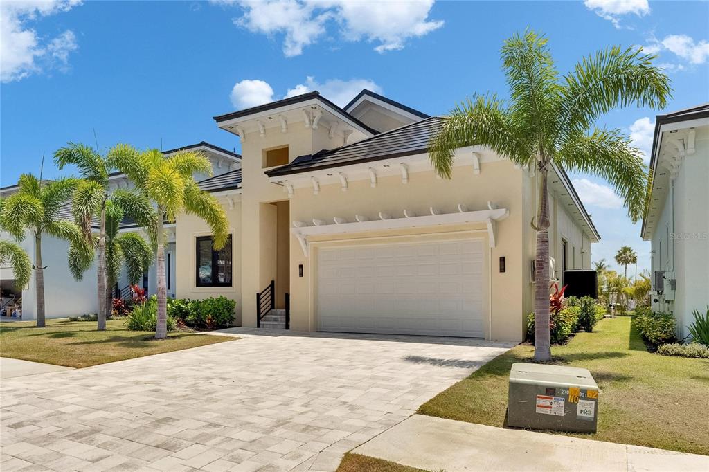 6532 Simone Shores Circle Apollo Beach, FL 33572 - Photo 70 of 86 a view of a white house with a yard and palm trees