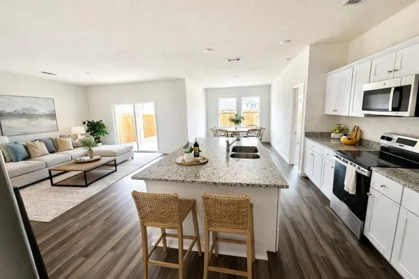 a living room with stainless steel appliances granite countertop furniture and a kitchen view