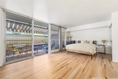 a spacious bedroom with a bed a table and painting on the wall