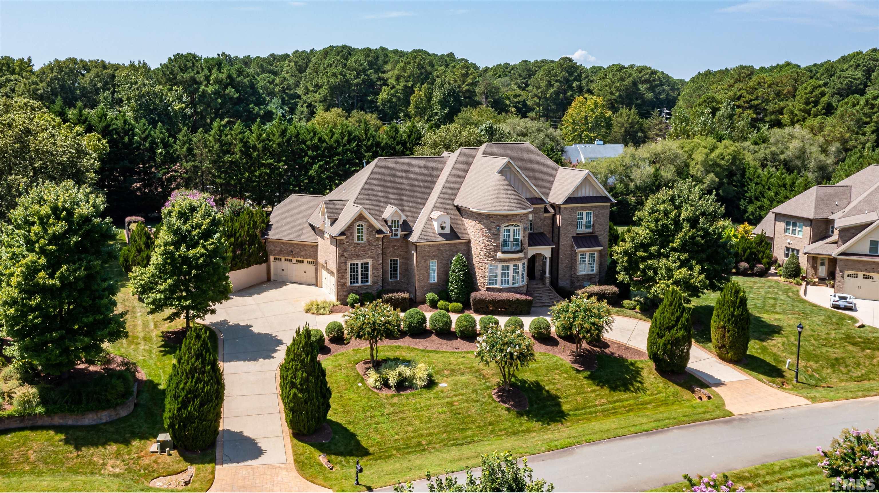 9805 Najma Street Raleigh, NC 27613 - Photo 2 of 29 a view of a white house with a yard plants and large tree