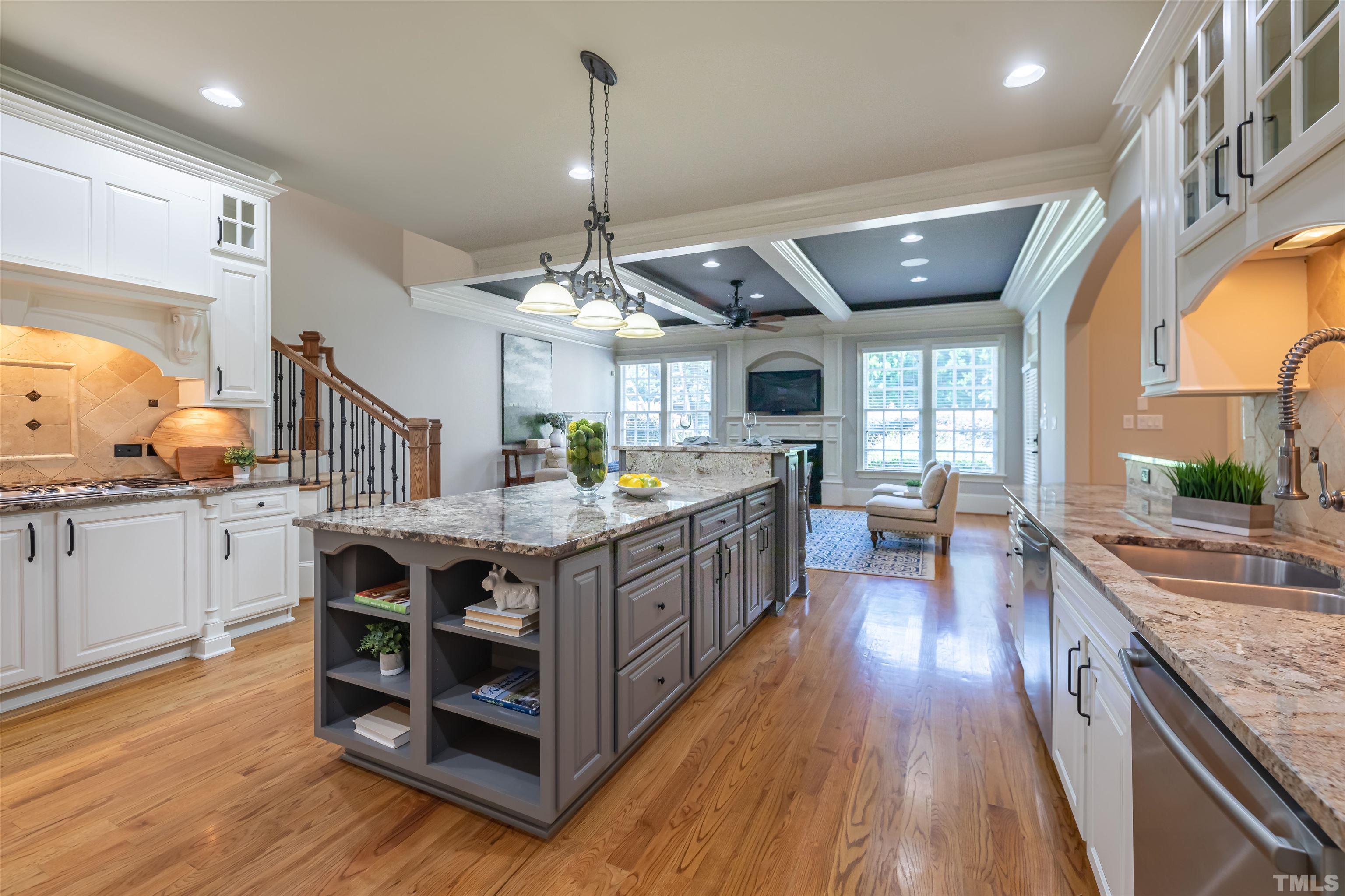 9805 Najma Street Raleigh, NC 27613 - Photo 11 of 29 a kitchen with stainless steel appliances granite countertop a lot of counter space and wooden floors