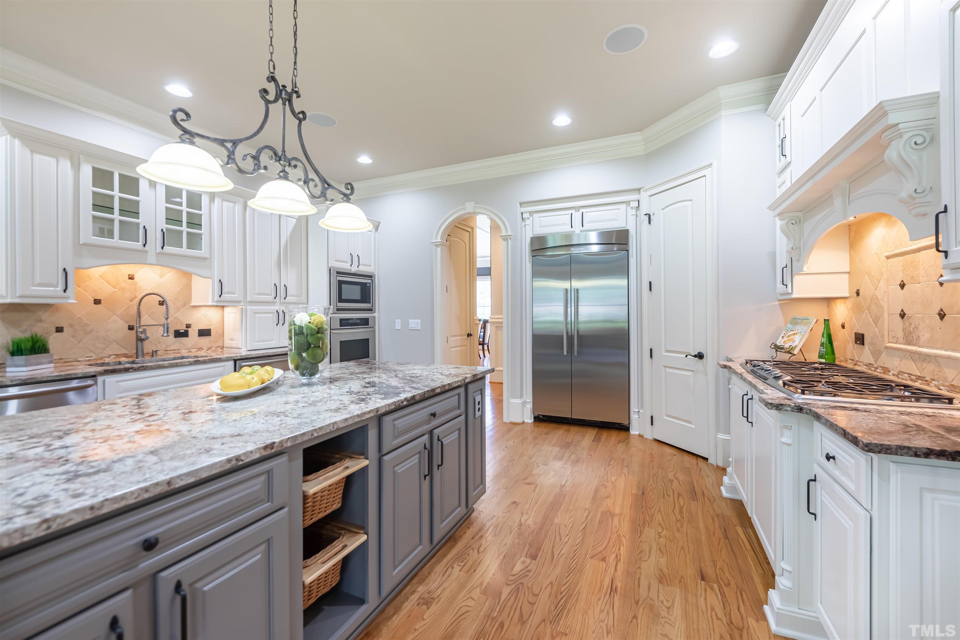 9805 Najma Street Raleigh, NC 27613 - Photo 13 of 29 a kitchen with stainless steel appliances granite countertop wooden floors and sink