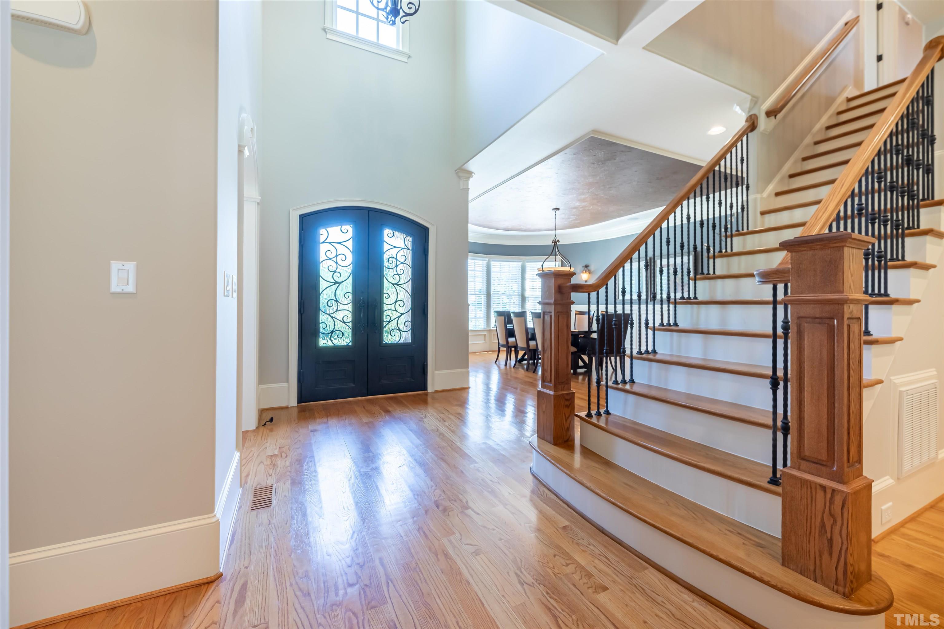 9805 Najma Street Raleigh, NC 27613 - Photo 3 of 29 a view of a hallway with wooden floor and stairs
