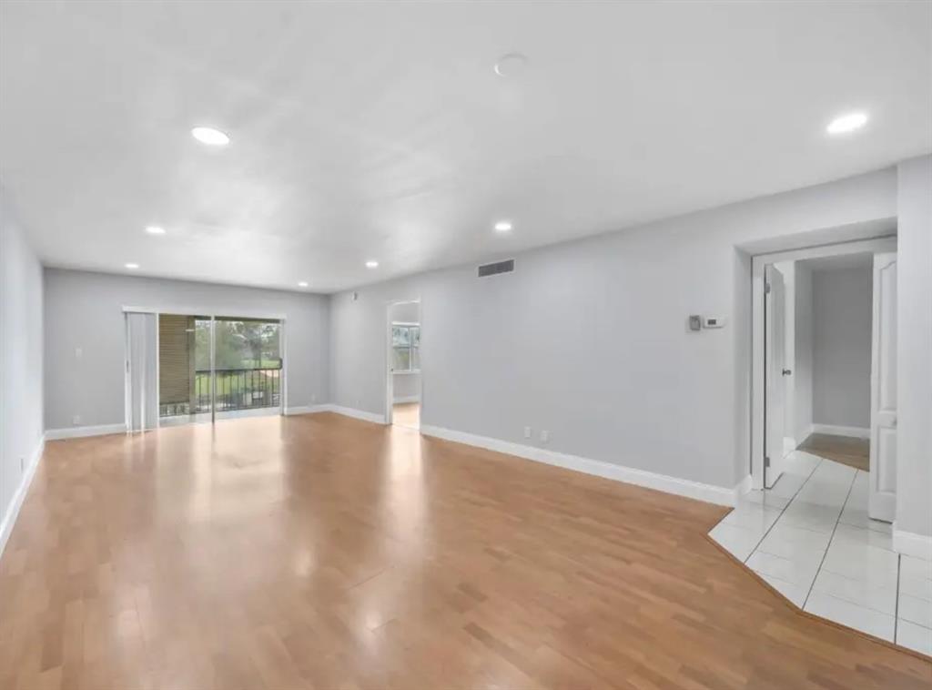 6100 South Falls Cir Drive, Unit 204 Lauderhill, FL 33319 - Photo 2 of 27 an empty room with wooden floor and windows