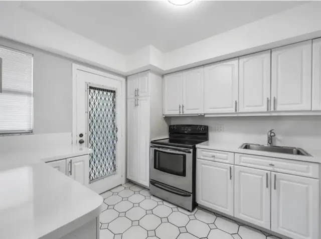a kitchen with white cabinets and appliances