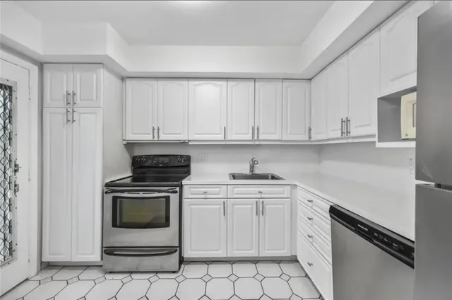 a kitchen with white cabinets and white appliances