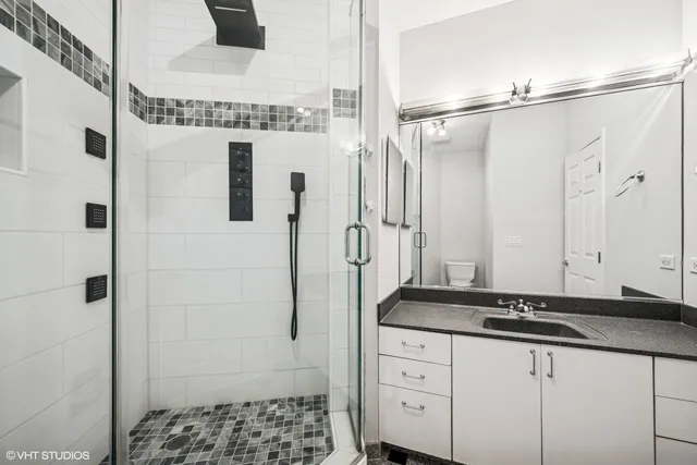 a bathroom with a granite countertop shower and a sink