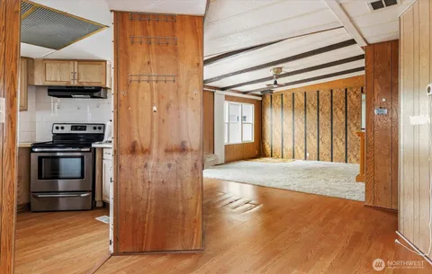 a view of a big room with wooden floor and windows