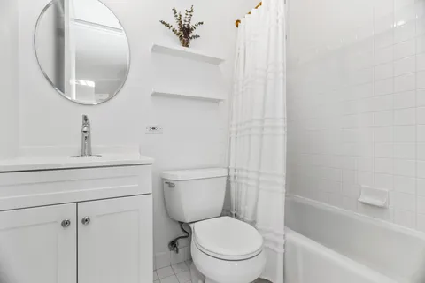 a white toilet sitting next to a bathroom sink and vanity