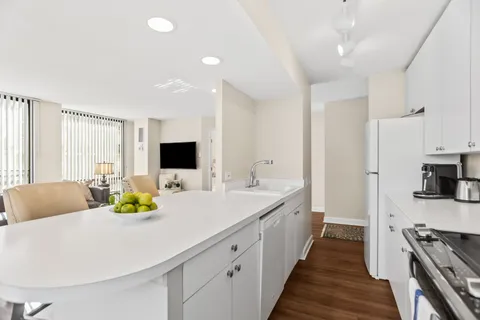 a large white kitchen with a large window and stainless steel appliances