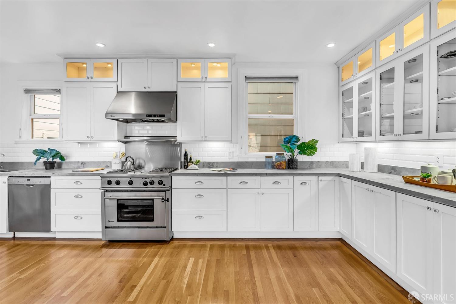 1049 Clay Street San Francisco, CA 94108 - Photo 11 of 28 a kitchen with stainless steel appliances a stove a sink and white cabinets