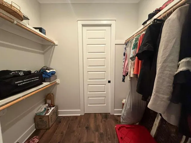 a view of walk in closet with clothes and shoes