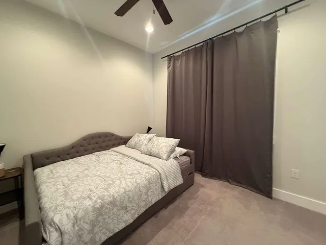 a bed sitting in a spacious bedroom next to a window