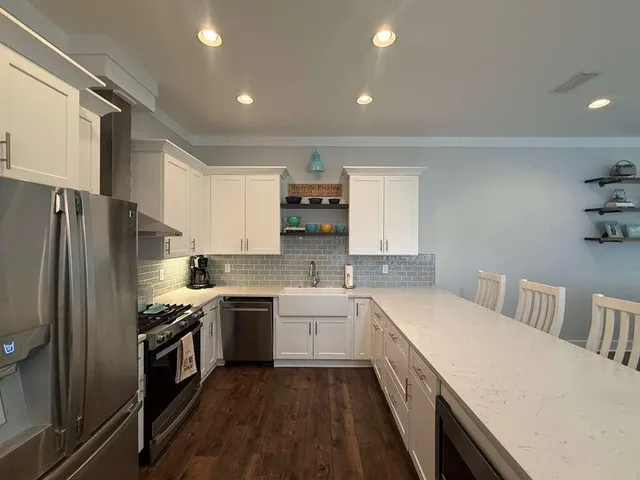 a kitchen with a sink stove cabinets and refrigerator