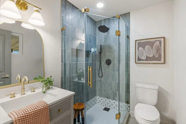 a bathroom with a sink a toilet and shower