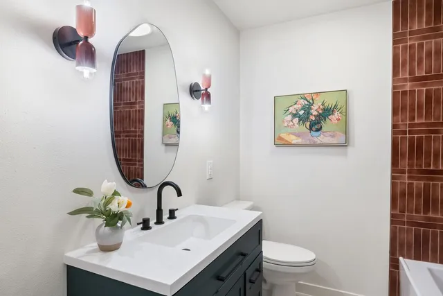 a bathroom with a sink mirror and toilet