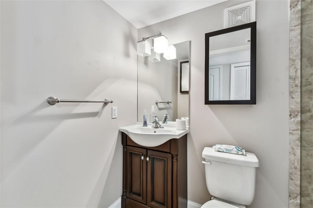 7701 Starkey Road, Unit 105 Seminole, FL 33777 - Photo 13 of 25 a bathroom with a sink mirror and toilet