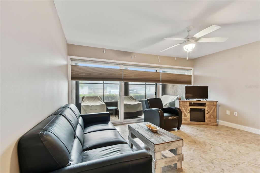 7701 Starkey Road, Unit 105 Seminole, FL 33777 - Photo 7 of 25 a living room with furniture a flat screen tv and a window