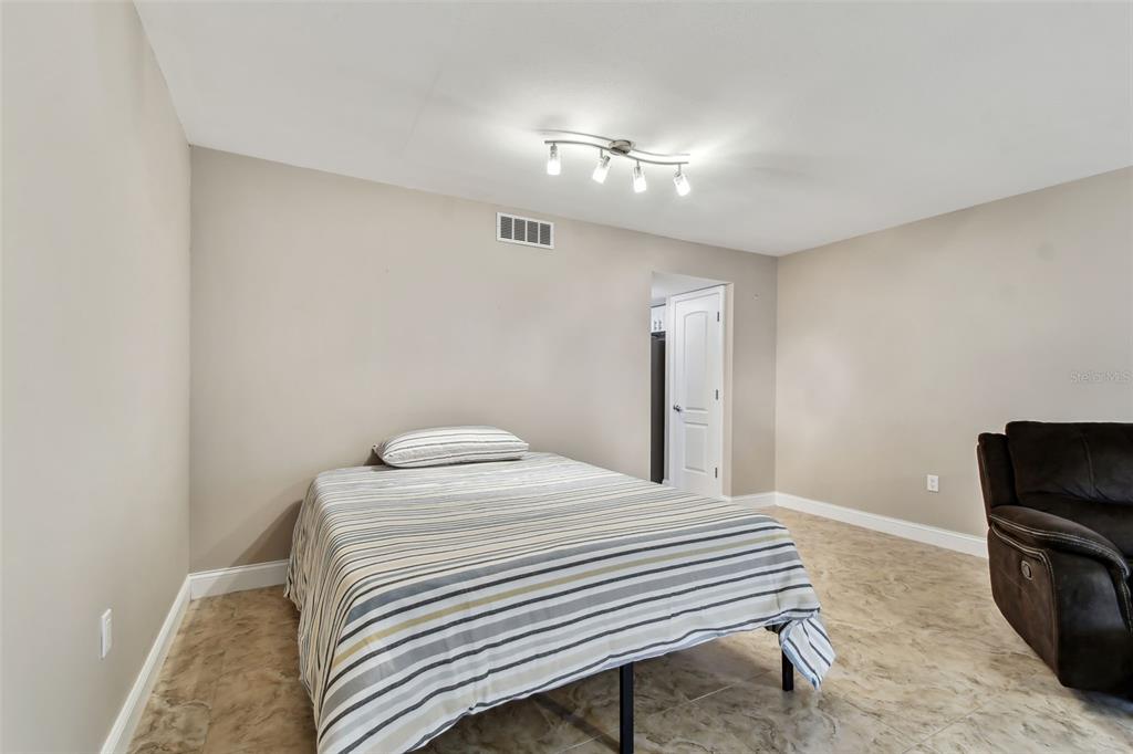 7701 Starkey Road, Unit 105 Seminole, FL 33777 - Photo 9 of 25 a bedroom with a bed and a television