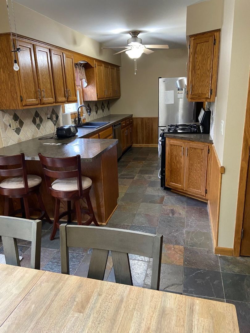 925 Knollside Road New Lenox, IL 60451 - Photo 11 of 32 a kitchen with stainless steel appliances kitchen island granite countertop a stove a sink and a microwave