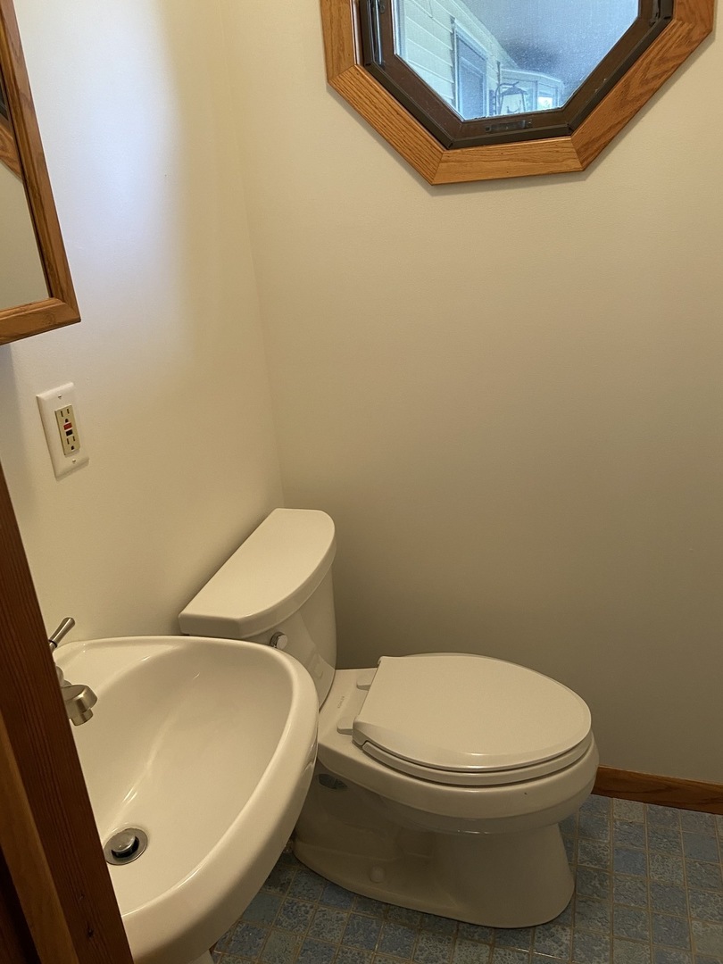 925 Knollside Road New Lenox, IL 60451 - Photo 14 of 32 a white toilet sitting next to a white sink and vanity