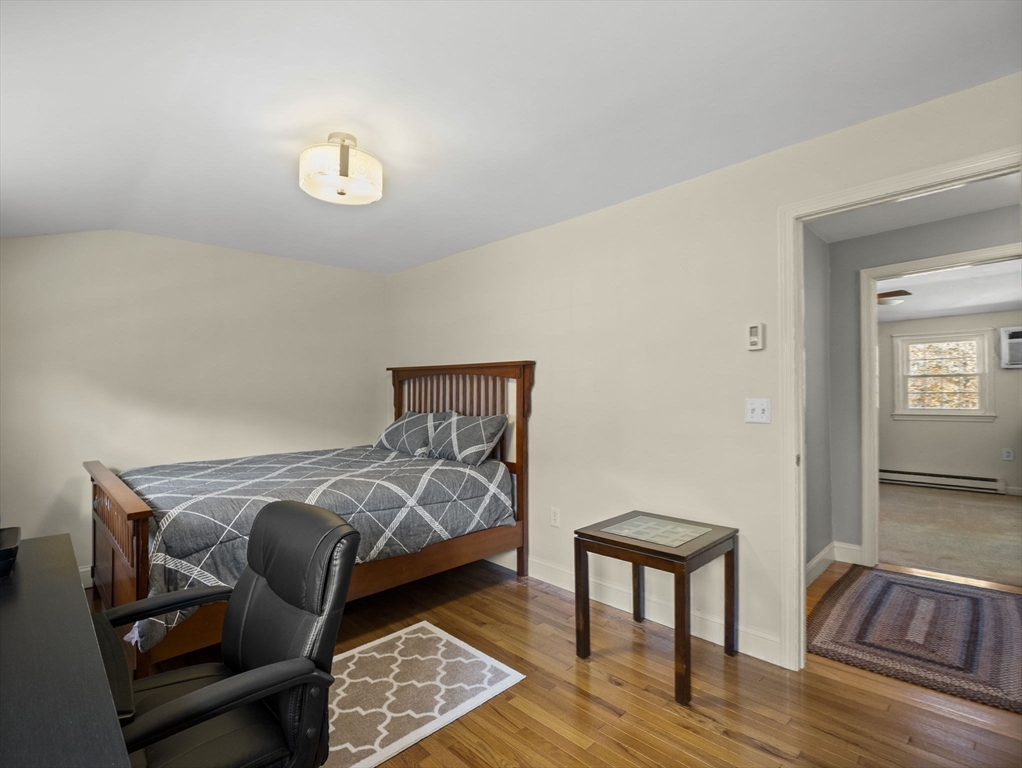 17 Cannongate Road, Unit 87 Tyngsborough, MA 01879 - Photo 16 of 39 a bedroom with furniture and a wooden floor