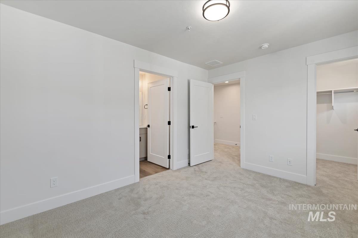 1725 South Rock View Lane, Unit 34 Boise, ID 83705 - Photo 25 of 31 Unfurnished bedroom with carpet flooring, a spacious closet, and a closet